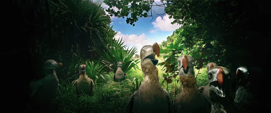 Multiple dodo replicas positioned within thick jungle foliage at Riviere des Anguilles, Mauritius, recreating an assembly of the disappeared creatures in their native tropical woodland environment.