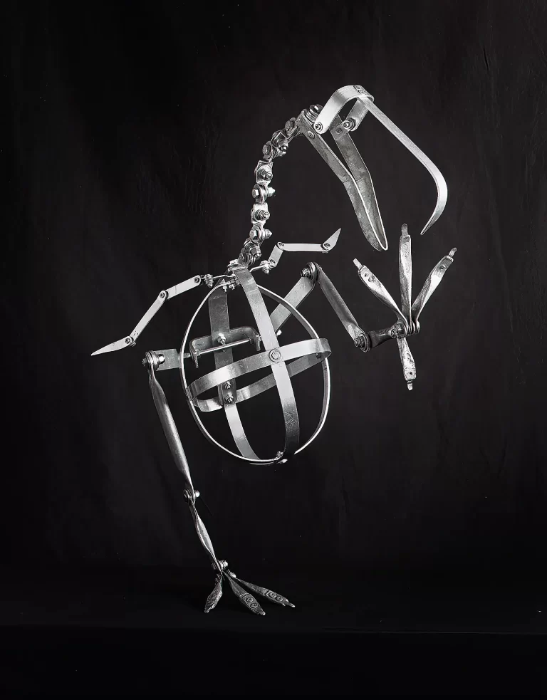 Black and white photograph of complex metal armature with adjustable joints and spherical cage designed for supporting dodo bird reconstruction. Professional museum-quality framework with precision hardware for positioning and articulating extinct species display model.